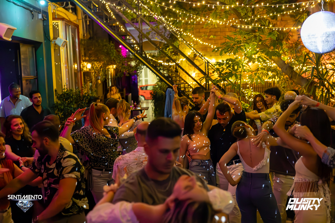 Couple dancing bachata under fairy lights